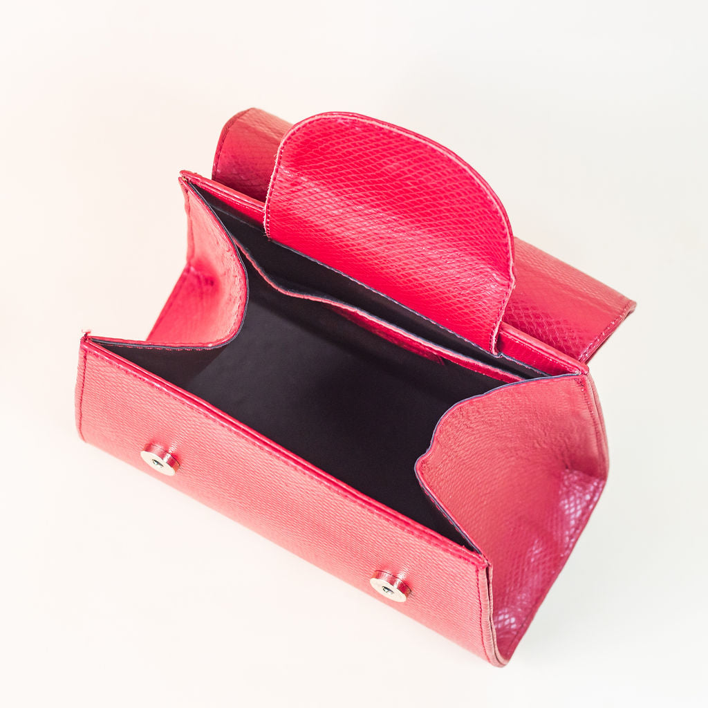 Discover the allure of this women's leather handbag in dark red hue. Featuring a structured cut, brand signature flap, brass accessories, and an adjustable strap, this handbag is the epitome of everyday elegance and style. Elevate your fashion with this chic accessory designed for the modern woman.