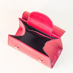 Discover the allure of this women's leather handbag in dark red hue. Featuring a structured cut, brand signature flap, brass accessories, and an adjustable strap, this handbag is the epitome of everyday elegance and style. Elevate your fashion with this chic accessory designed for the modern woman.