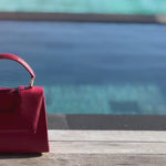 Discover the allure of this women's leather handbag in dark red hue. Featuring a structured cut, brand signature flap, brass accessories, and an adjustable strap, this handbag is the epitome of everyday elegance and style. Elevate your fashion with this chic accessory designed for the modern woman.